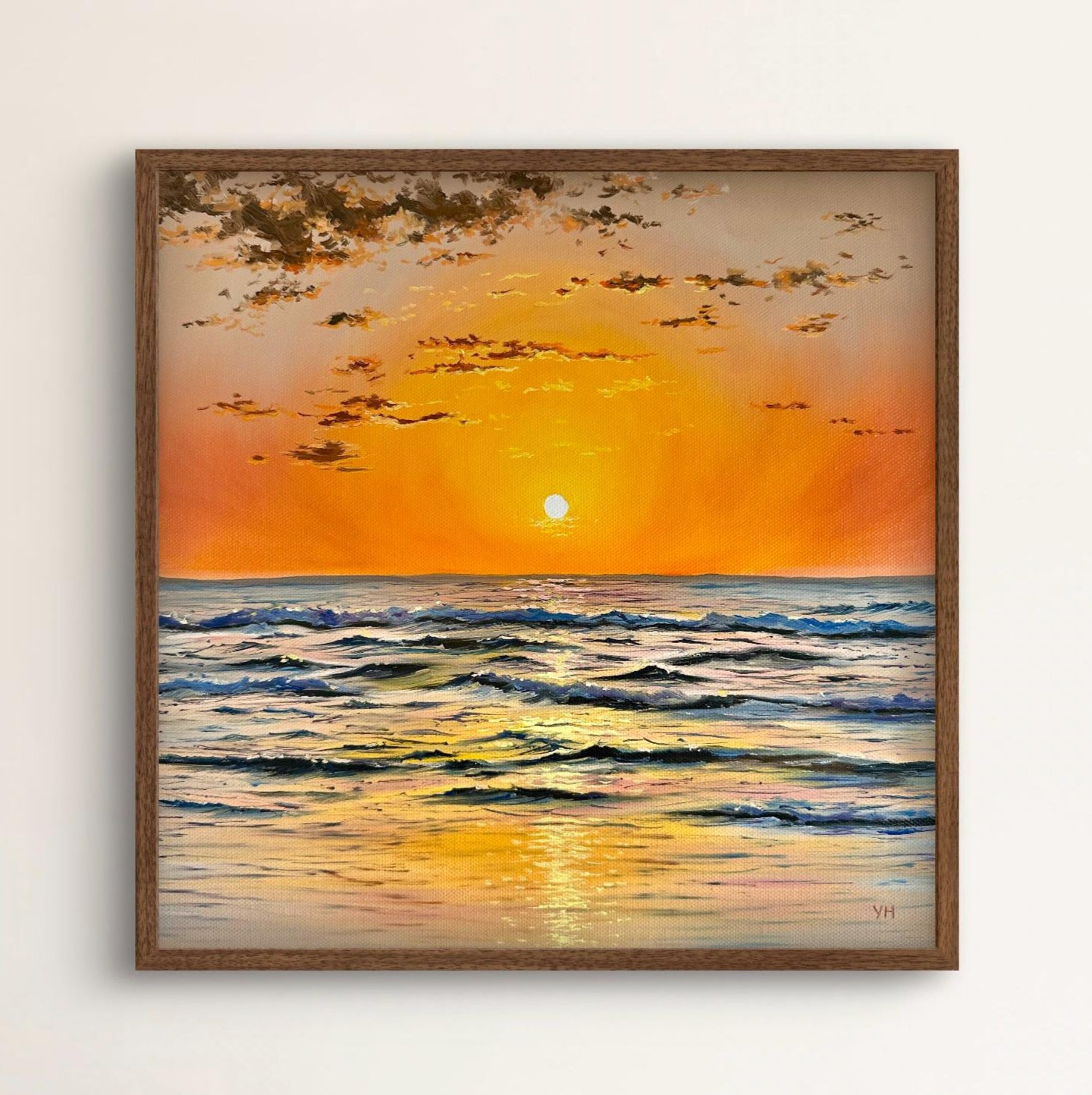 Framed painting of a sunset over the ocean with a wooden frame.