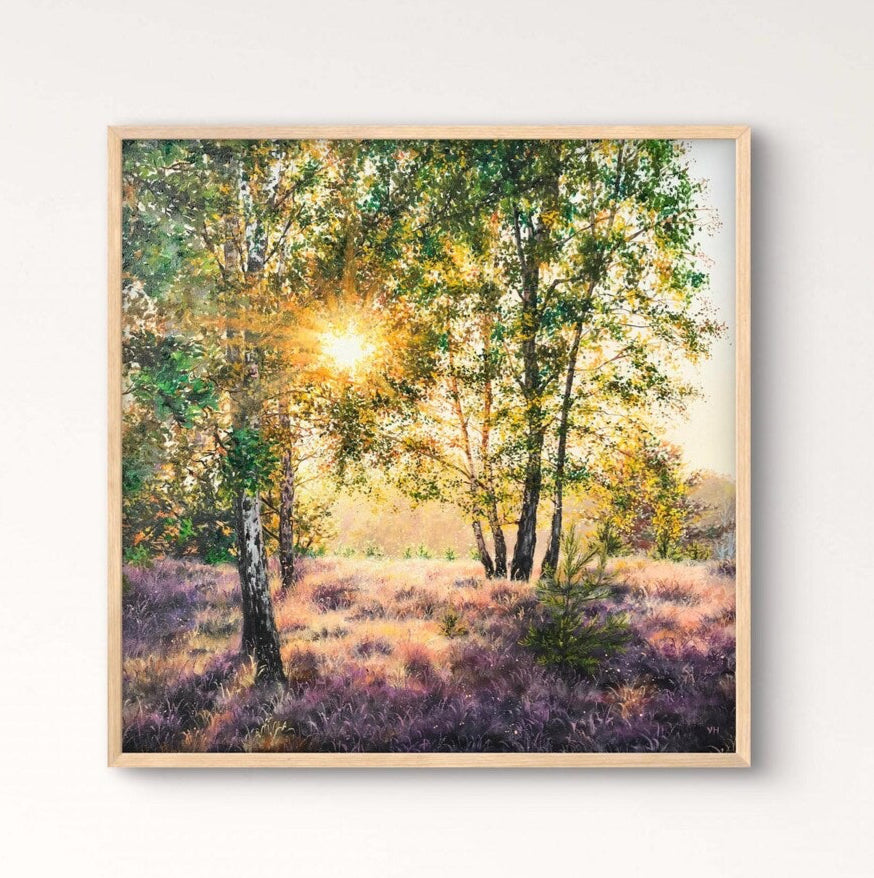 Framed artwork of a forest scene on a wall above a wooden table with a vase.