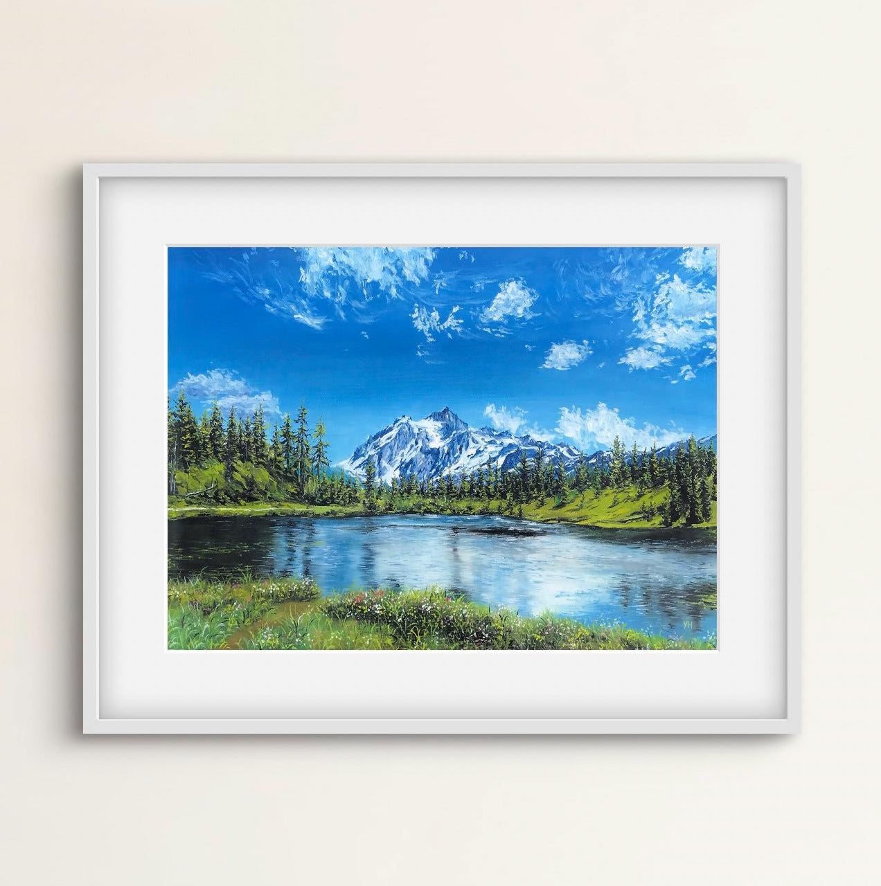 Framed artwork of a mountain landscape with a lake on a beige wall.