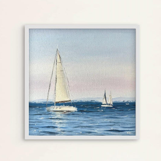 Framed artwork of sailboats on a body of water with a light blue sky.