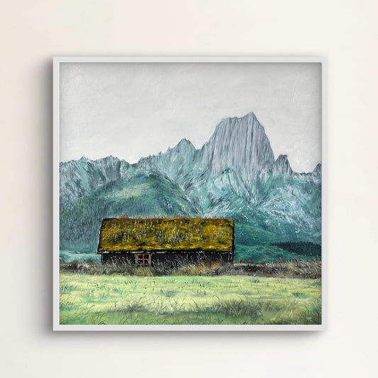 Framed artwork of a mountain landscape with a green cabin.