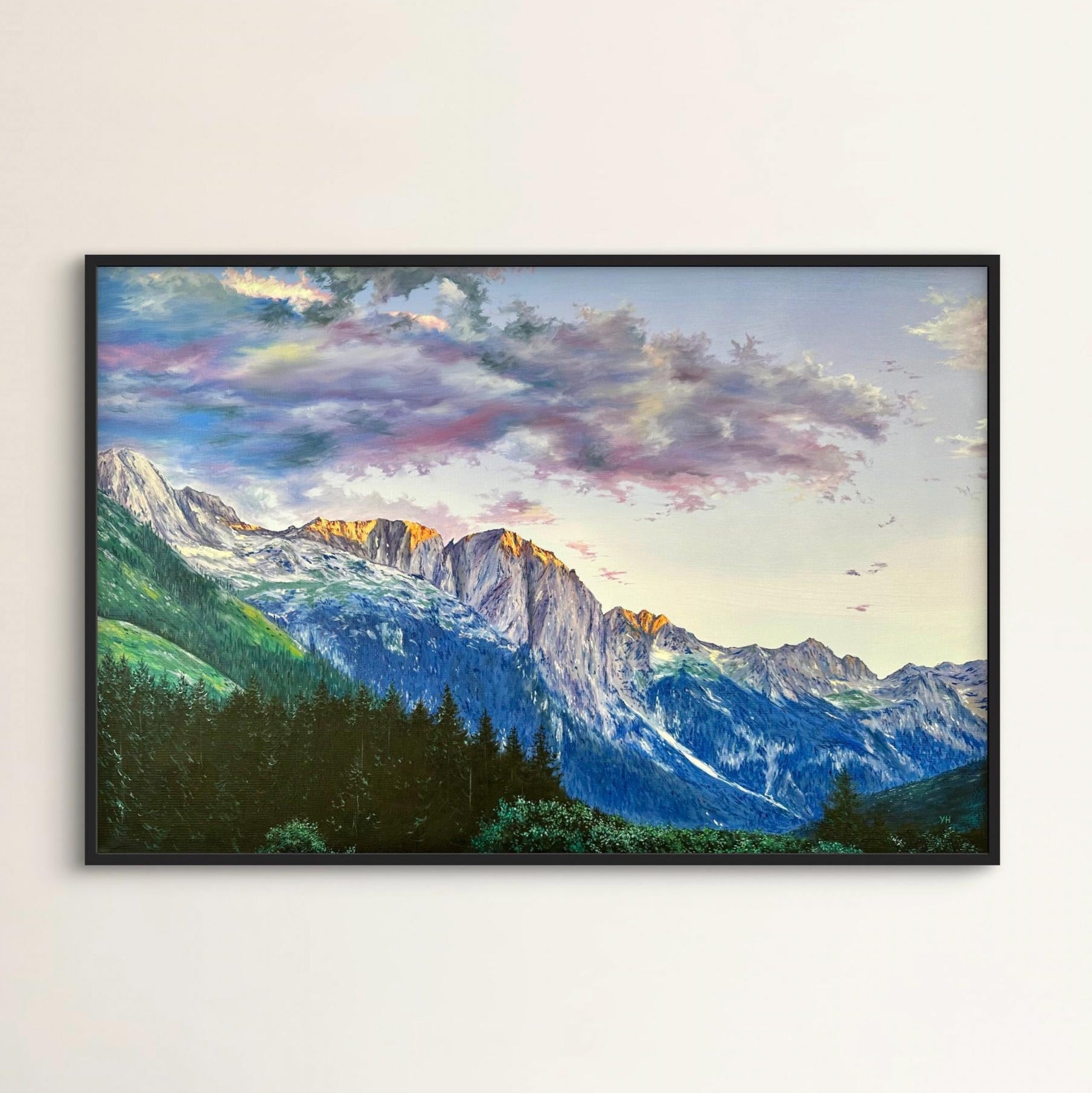 Framed painting of a mountain landscape with a colorful sky.