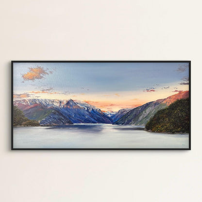 Framed artwork of a mountain landscape with a lake on a white wall