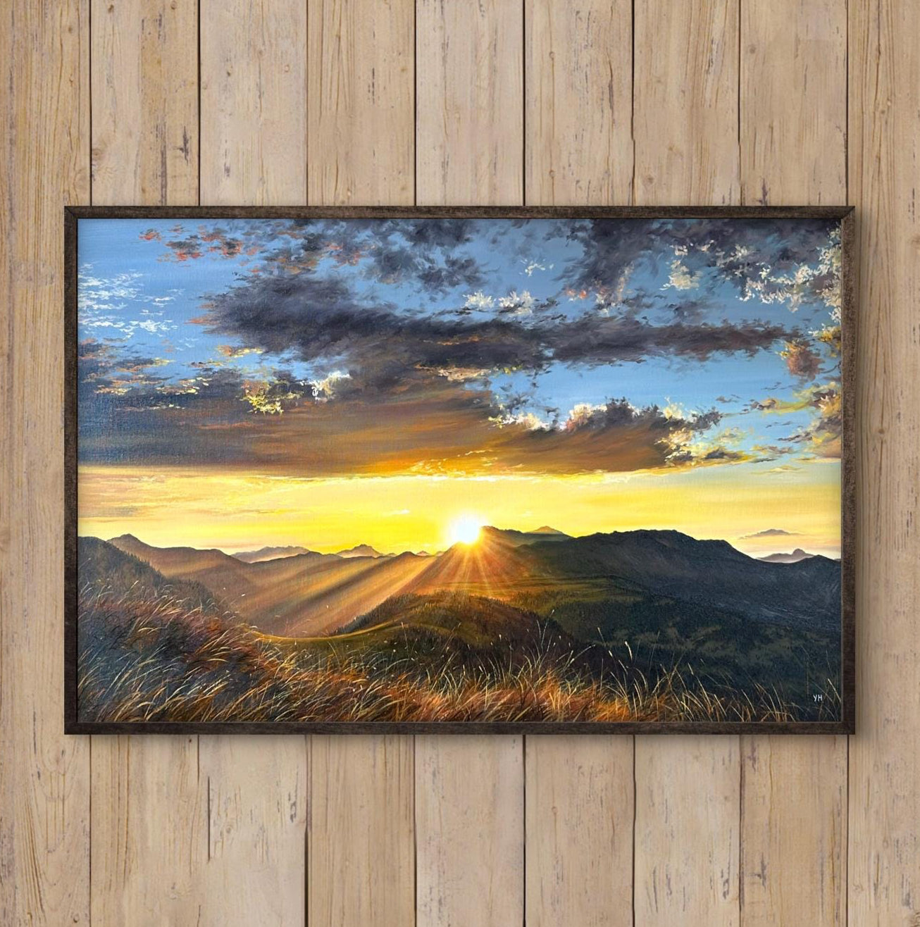 Framed landscape painting on a wooden wall above a white armchair.